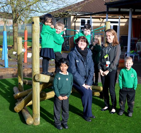 Photo of Tesco community champion Dawn Richards (seated) with Reception teacher Wendy Collins and pupils.