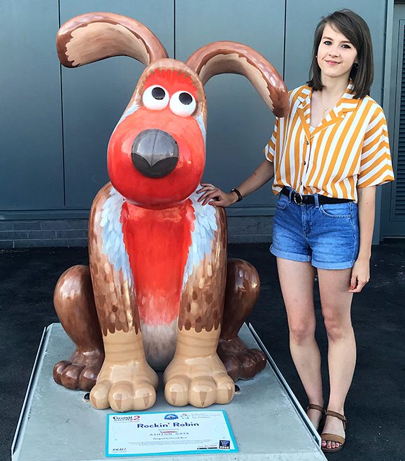 Photo of Hannah Bone with Rockin' Robin, the giant Gromit figure she painted for the Gromit Unleashed 2 arts trail.