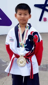 Photo of Nathan Wong wearing his world championship gold medal.
