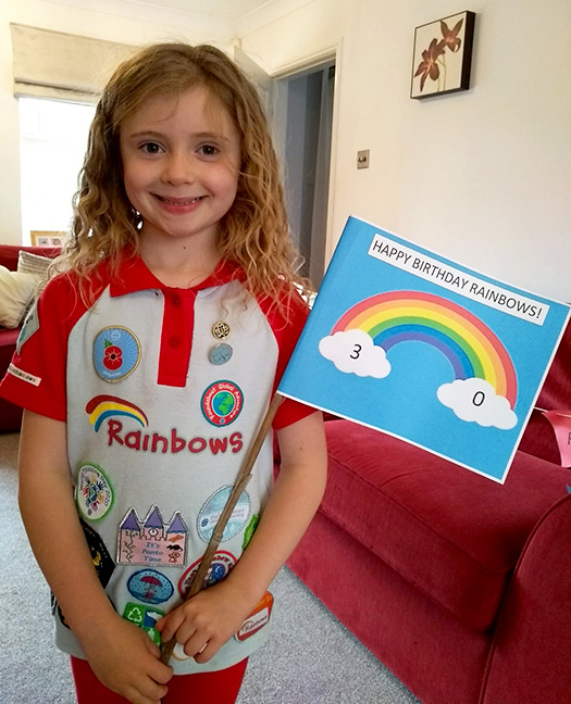 Photo of a Rainbow Guide celebrating the unit's 30th birthday at home.