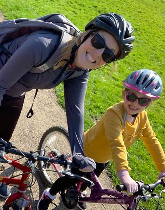 Photo of Ella (accompanied by her mum) on a bike ride.