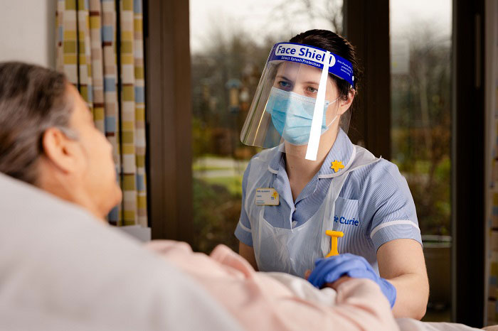 Photo of a Marie Curie nurse wearing a protective visor.