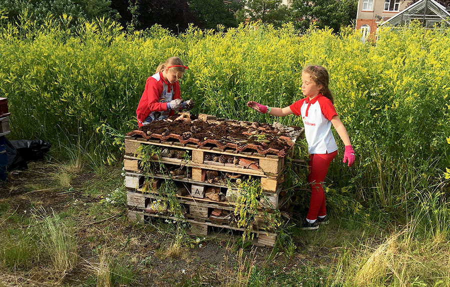 Photo of two children with a stack of pallets.