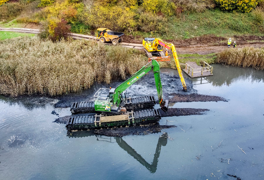 Aerial photo of an amphibious excavator working in a lake.