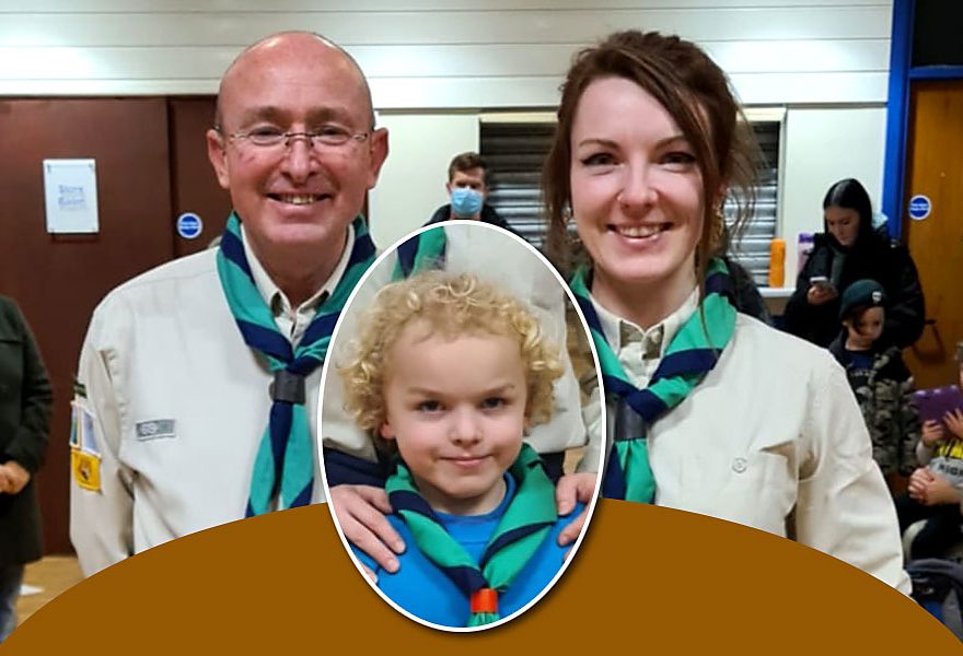 Photo of two adults and a child in Scout uniform.