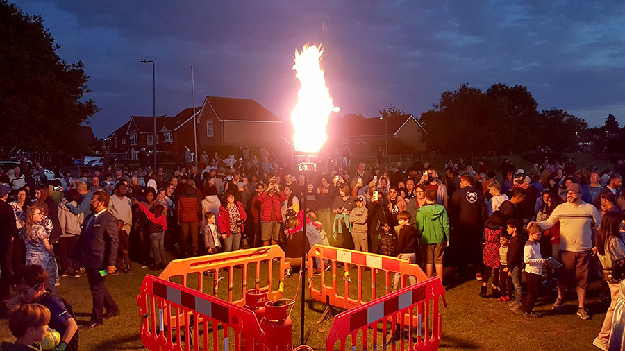 Photo of a large crowd around a burning beacon.