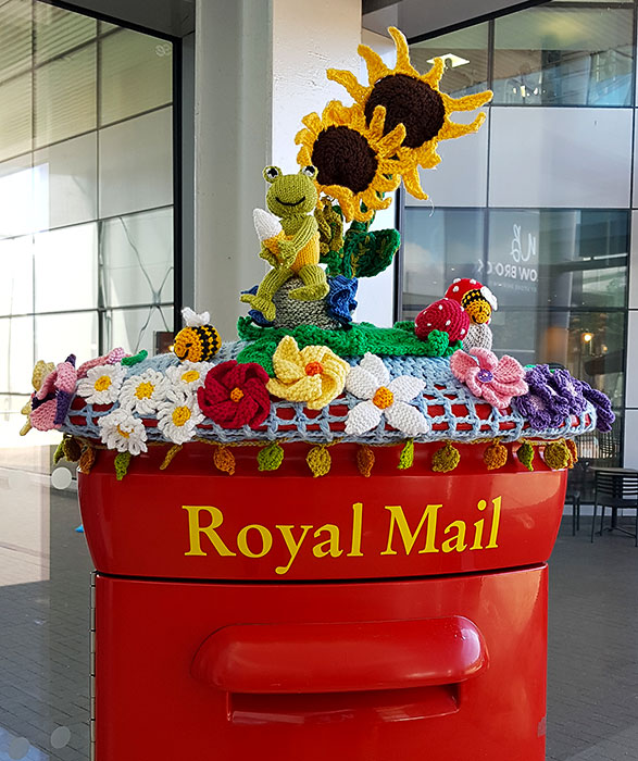 photo of a crocheted display on top of a Royal Mail postbox.