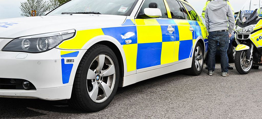 Photo of a police car and a police motorcycle.