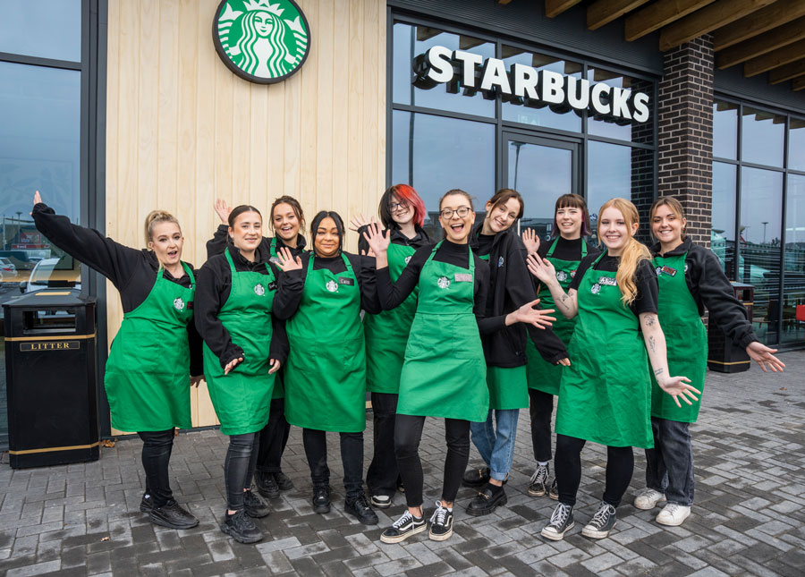 Photo of a group of employees standing outside a Starbucks restaurant.