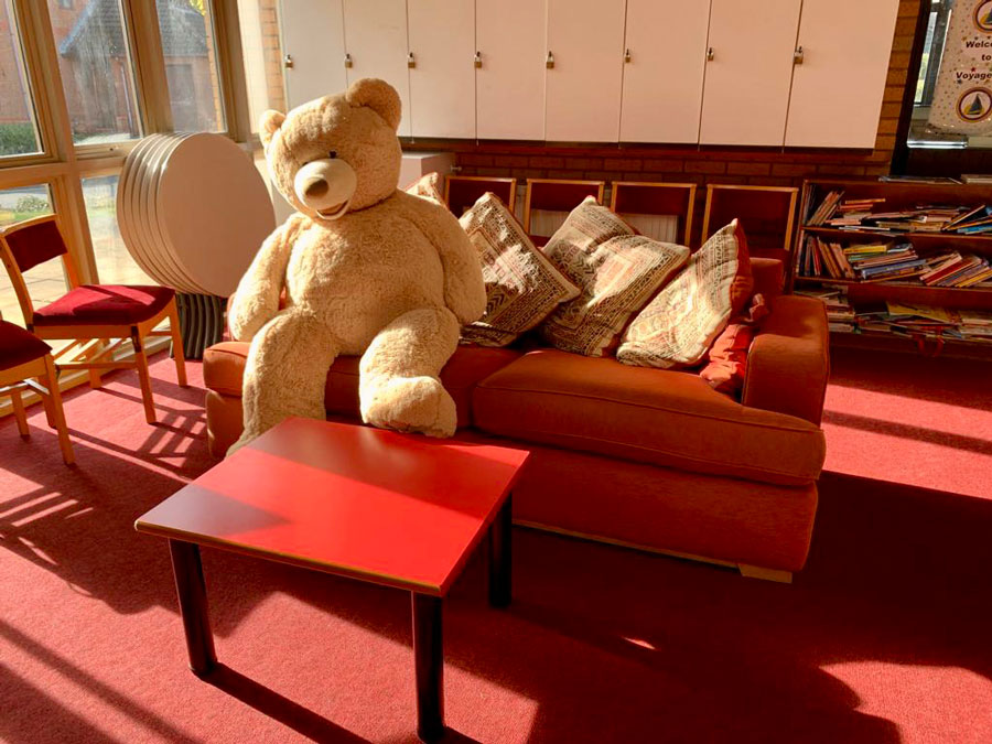 Photo of a teddy bear on a sofa.