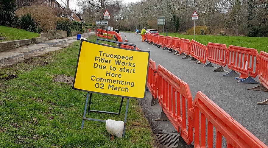 Photo of a yellow information sign next to some roadworks.