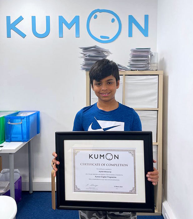 Photo of a young student holding a framed certicate.