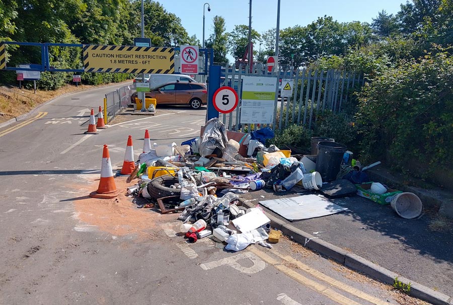 Photo of fly-tipped waste outside the gates of a recycling centre.