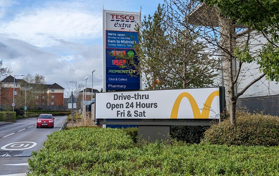 Photo of an advertising sign displaying: "Drive-thru open 24 Hours Fri & Sat".