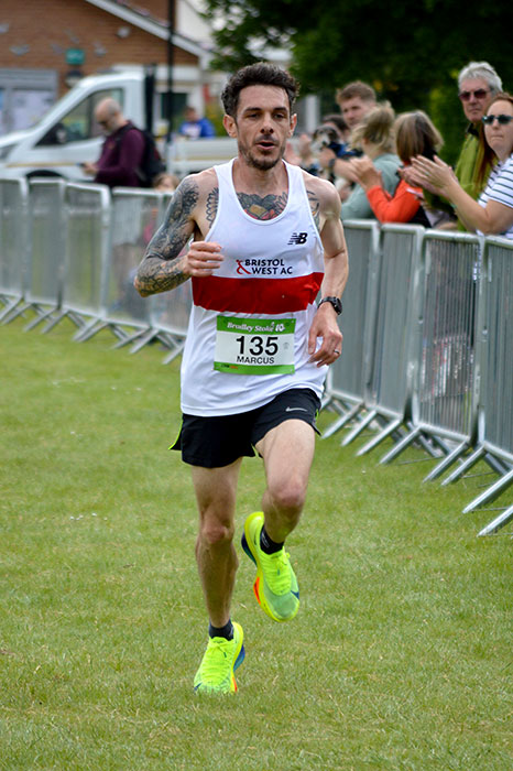 Photo of a male runner approaching the finish of a race.