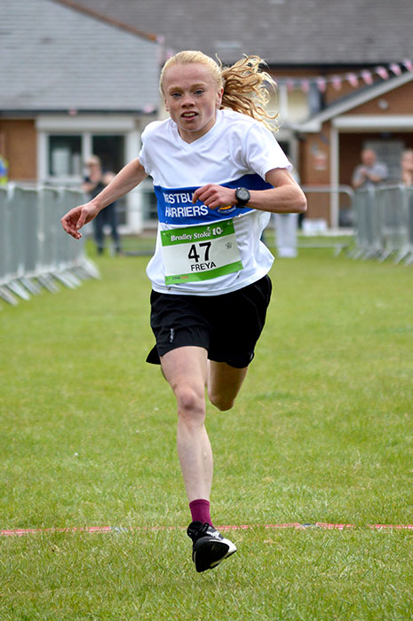 Photo of a female runner approaching the finish of a race.