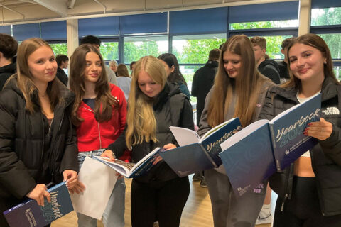 Photo of a group of students holding yearbooks.