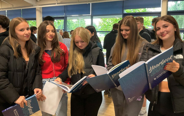 Photo of a group of students holding yearbooks.