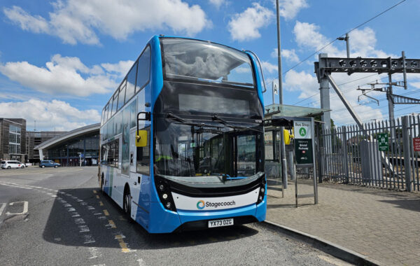 Photo of a bus waiting at a stop.