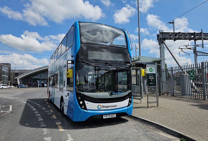 Photo of a bus waiting at a stop.