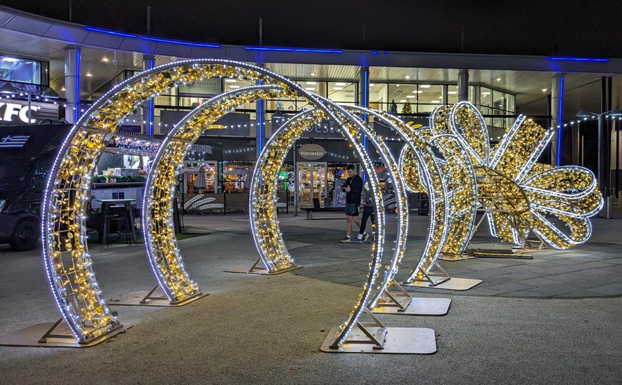 Photo of illuminated Christmas decorations in the form of hoops and a bow,